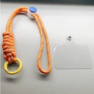 Adjustable orange paracord wrist lanyard for phone with clear tether tab.