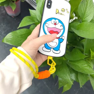 Hand-woven yellow phone lanyard strap with cute character phone case in outdoor setting
