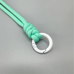 Handcrafted mint green woven phone wrist strap with a white circular metal spring clasp