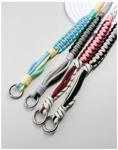 Detail van vier handgeweven paracord tasriemen in verschillende levendige kleurcombinaties.