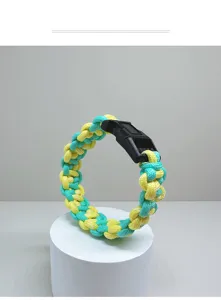 Detail of hand-woven yellow and blue paracord survival bracelet with black buckle.