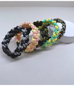 Macro view of braided paracord survival bracelets in various vibrant color combinations