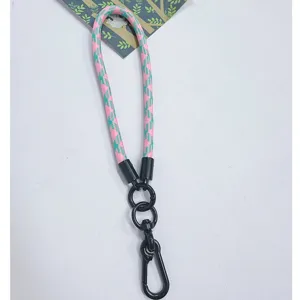 Close-up detail of a durable pink and green braided wrist lanyard with a black metal clasp