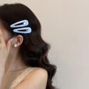 Primo piano di fermagli per capelli a goccia blu chiaro indossati da una modella