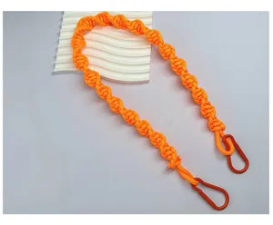 Close-up of neon orange hand-woven bag strap with red carabiner clips for crossbody bags.