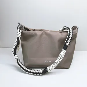 Taupe nylon schoudertas met handgeweven zwart-witte gevlochten koord schouderband