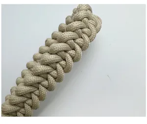 Close-up of handmade braided beige phone wrist strap with intricate nylon weave texture.