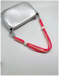 Détail de la sangle en corde tissée rose et orange avec clips argentés sur sac