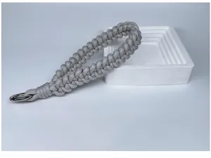 Detailed view of grey braided paracord wrist strap with durable metal ring hook