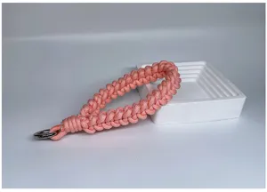 Macro view of handmade braided coral wrist lanyard strap with metallic silver ring