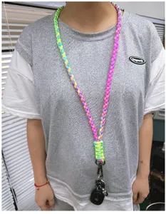 Colorful braided paracord neck lanyard for keys and outdoor survival, worn by model.