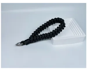 Detailed macro view of handmade black braided paracord wrist strap lanyard
