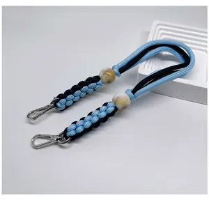 Détail de la lanière tressée à la main bleue et noire avec des fermoirs mousquetons.