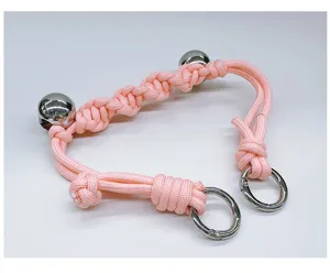 Detailed view of hand-woven pink rope bag strap with polished metal rings and beads