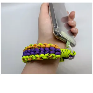 Handgewebtes Handy-Armband aus Paracord in Neon-Gelb, Orange und Violett in der Hand.