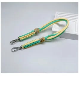 Détail d'une dragonne de téléphone tissée à la main jaune et vert menthe