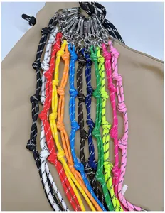 Detail view of various colorful braided lanyards with silver carabiners for bag accessories