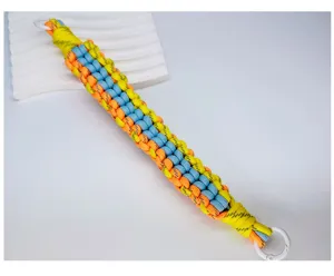Detailansicht der bunten, dreifarbigen, geflochtenen Textur des breiten Handy-Armbands.