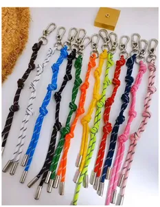 Assorted colorful woven cord bag charms with silver carabiner clasps and metal tips.