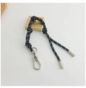 Close-up of stylish black braided rope lanyard with silver metal climbing buckle for bags