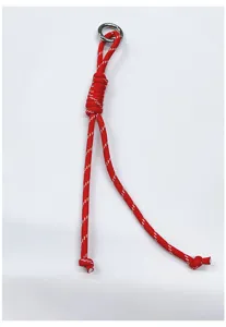 Detail of a red braided paracord bag charm with a silver metal ring.