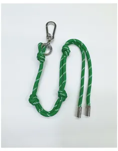 Detail view of green and white braided cord bag charm with silver carabiner clasp