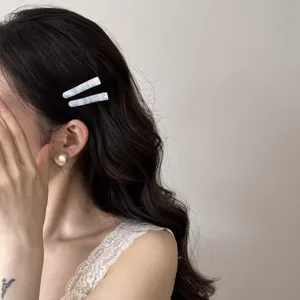 Vue détaillée de pinces à cheveux bleu clair texturées sur des cheveux ondulés