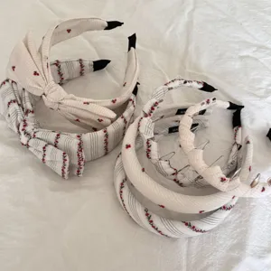 Detail view showing variety of cherry pattern fabric hairbands on white background