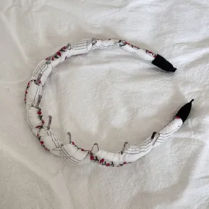Detail view of sweet cherry pattern fabric headband with clear plastic styling clips
