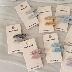 Détail de diverses barrettes à cheveux ovales à carreaux sur cartes de présentation