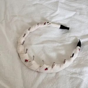 Detailed view of sweet cherry pattern on plaid fabric headband for girls.
