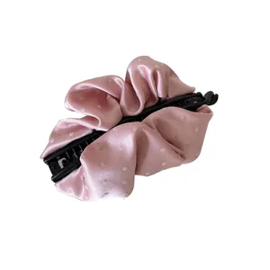 Elegant pink satin ruffled banana hair clip with white polka dot pattern on white background