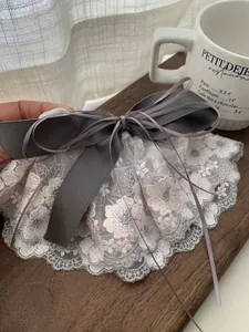 Vue détaillée d'une pince à cheveux avec nœud en ruban gris et dentelle florale rose