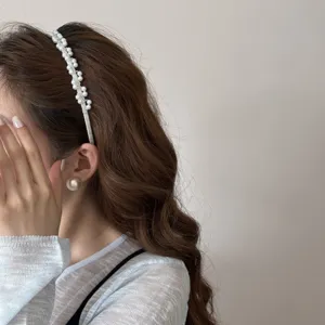 Detailopname van een elegante parel hoofdband in Franse stijl op een vrouwelijk model