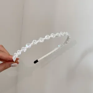 Detailopname van een elegante Franse haarband met witte parels en kristallen kralen