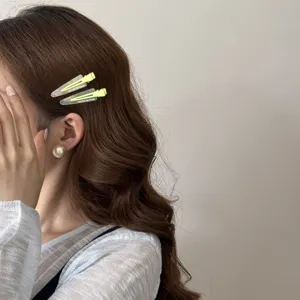 Vue détaillée de barrettes à cheveux bec de canard vert néon et transparentes