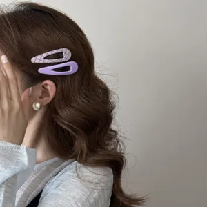 Gros plan sur des barrettes en tissu lavande portées sur des cheveux bruns ondulés