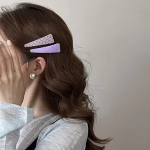 Gros plan sur des barrettes en tissu violet de style coréen et un clip BB à carreaux