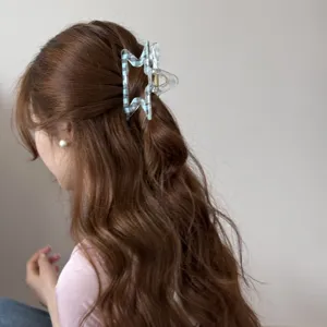 Vista detallada de una pinza para el pelo con forma de estrella y cuadros en un peinado.