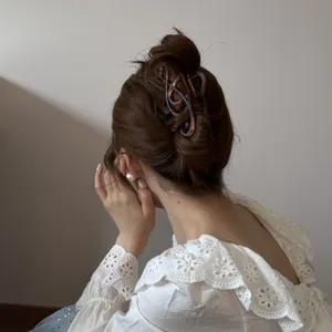 Vista detallada de una elegante pinza para el cabello con forma de nota musical en un moño