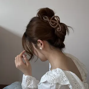 Primer plano de una pinza para el cabello marrón con forma de nota musical elegante