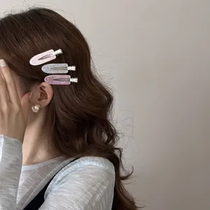 Close-up of three colorful acrylic water-drop hair clips styled on model's wavy hair