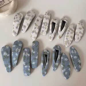 Détail de barrettes à cheveux en tissu avec motifs de feuilles en plusieurs formes