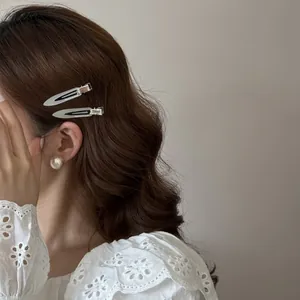 Vue détaillée de deux barrettes à cheveux étroites en acétate sur des cheveux ondulés