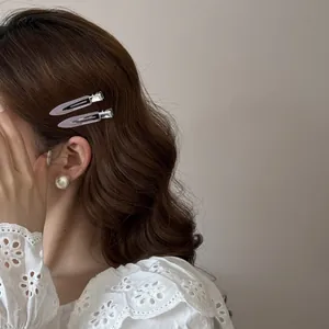 Vue détaillée de deux barrettes en acétate lavande élégantes sur cheveux ondulés
