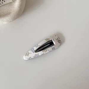 Détail d'une pince à cheveux BB en tissu fleuri doux pour femmes et filles