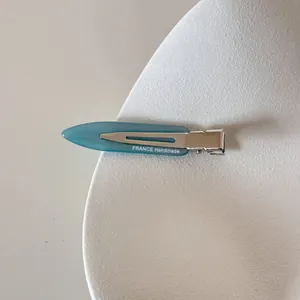 Détail macro d'une pince à cheveux en acétate bleu clair avec texte FRANCE Handmade blanc