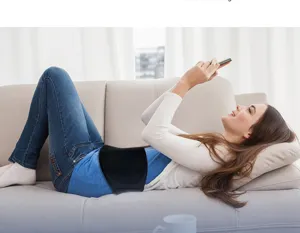 Frau mit Taillen-Kältekompresse-Gelpack auf Sofa liegend und Handy benutzend