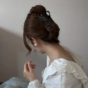 Vista posterior de una mujer con una pinza para el cabello negra con forma de nota