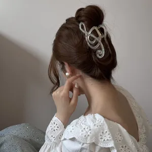 Vista detallada de una elegante pinza para el cabello iridiscente con forma de nota musical